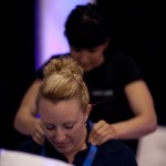 Professional therapist performing seated event massage at a corporate function